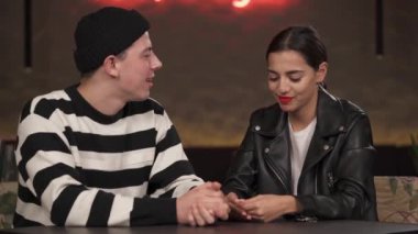 Lokanta masasında oturan aşk çifti. Erkek kadının ellerine dokunuyor. Kafede yemek yiyen mutlu çift. Romantik randevu kavramı