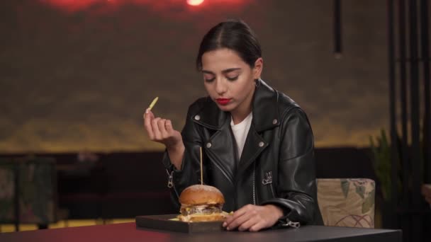 Şehirdeki Restoranda Fast Food Hamburger Patates Kızartması Yiyen Çekici Genç — Stok video