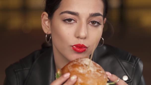 一位红唇美女在快餐店吃着新鲜熟食大汉堡的特写照片 美国街头食品概念 — 图库视频影像
