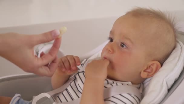 Zblízka Video Veselého Chlapečka Tmavohnědýma Očima Ležícího Dětské Sedačce Žvýkajícího — Stock video