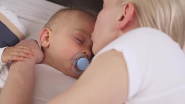 Detailní Záběr Starostlivé Matky Jemně Líbající Svého Pokojně Spícího Syna — Stock video