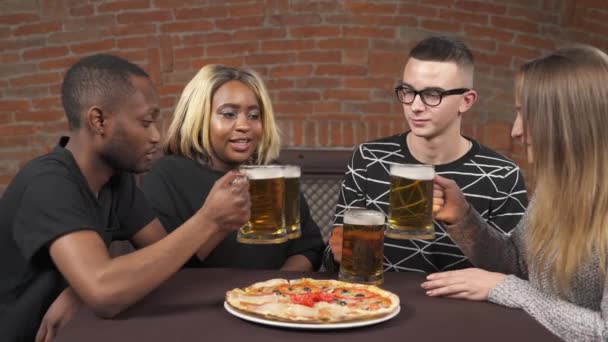 パブで楽しい2人の若いカップルの会社 人々はビールを飲んでピザを食べています レジャーコンセプト 多民族友好 — ストック動画