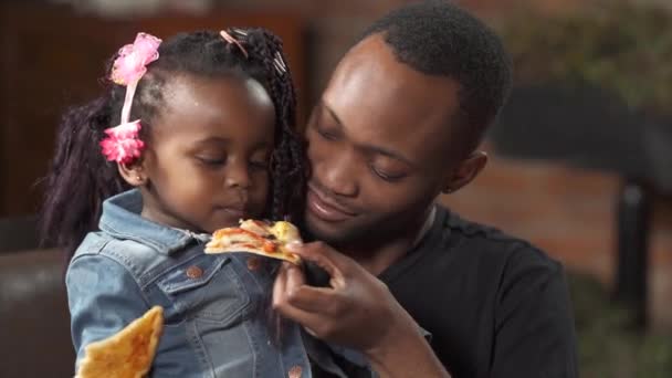 Młody Afro Amerykański Ojciec Karmiący Swoją Uroczą Córeczkę Pizzą Restauracji — Wideo stockowe