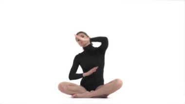Yoga yapan ve Padmasana 'da oturan genç bir kadın. Profesyonel sporcu yan eğilim sergiliyor.