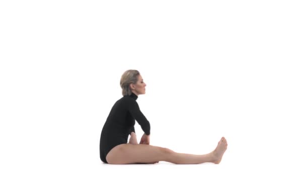 瑜伽垫女人伸展髋关节 腿筋肌肉和腹股沟区域 倾斜在前面 健康的白人健美运动员女孩运动时穿着运动服伸展身体 — 图库视频影像