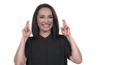 Parmakları çapraz olan, beyaz tenli mutlu bir kadının yakın plan portresi. Dileklerin gerçekleşmesi kavramı