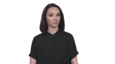 Gülümseyen kadın kollarını kavuşturuyor ve işaret parmağı, vücut dili, jest konsepti göstermiyor. Alaycı bir şekilde reddedildiğini gösteren bir model. İzole edilmiş, beyaz arkaplanda