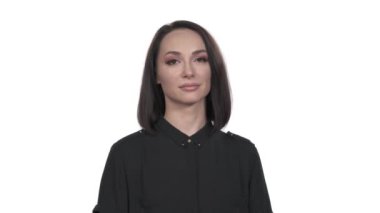 Güzel bir kadın gösteri için buraya geldi. Gülümseyen model kameraya kur yaparak poz veriyor. El işareti, kendinden emin hareket. İzole, beyaz arkaplan