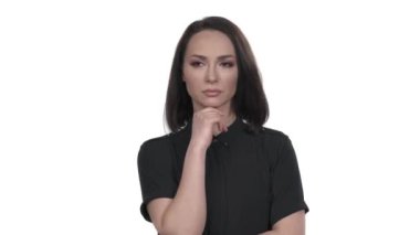 Çekici genç bir kadın düşünürken çenesine dokunuyor ve işaret parmağını kaldırıyor. Vücut dili ve jest kavramı. Zekice bir jest. İzole edilmiş, beyaz arkaplanda