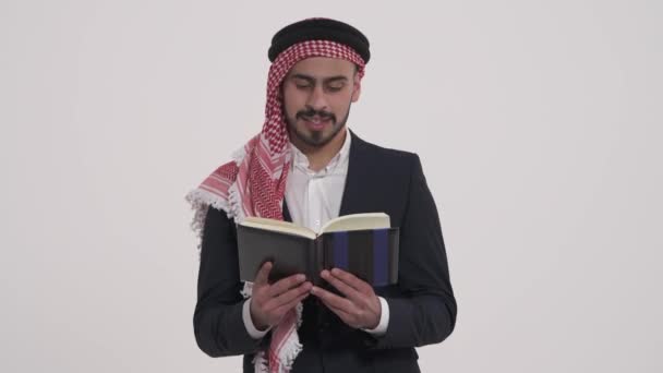 Surpreendido Árabe Lendo Livro Mostrando Polegar Para Cima Isolado Sobre — Vídeo de Stock