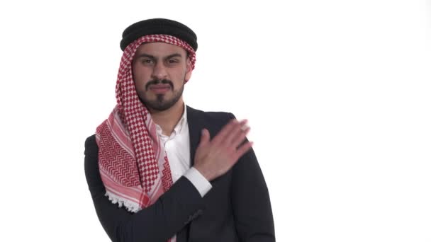 一个英俊的阿拉伯男子站在白色背景下从肩上抖落灰尘的画像 — 图库视频影像
