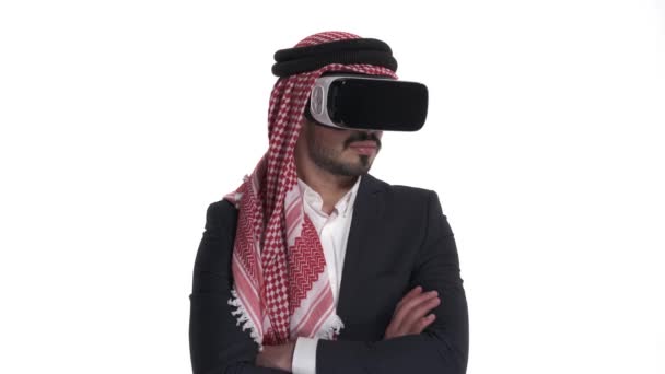 戴着虚拟现实眼镜的阿拉伯年轻人朝两边望去 在白色背景下孤立无援 — 图库视频影像