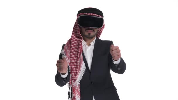 年轻的阿拉伯男子戴着虚拟现实眼镜 模仿开车 向右看 3D小工具 高保真技术的概念 在白色背景下孤立无援 — 图库视频影像