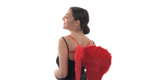 カメラにポーズをとって赤い翼を持つ美しい女性のクローズアップ バレンタインデーのコンセプト 隔離された白い背景に — ストック動画