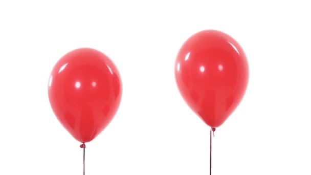 两个红色气球的特写演示视频 从相机的视野中消失 在白色背景下孤立无援 — 图库视频影像