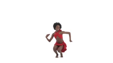 Kırmızı bez dansına sarılmış Afrikalı bir kadının tam boy fotoğrafı. Dansçı çömeldi ve kameraya yaklaşıyor. İzole edilmiş, beyaz arkaplanda