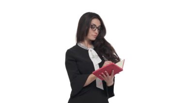 Gözlüklü genç beyaz kadın portresi bir şey icat ediyor ve not defterine yazıyor. Beyaz arkaplanda izole