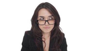 Gözlüklü genç beyaz kadın kameranın önünde dilini dışarı çıkararak oynaşıyor. Neşeli bir ruh hali. Beyaz arkaplanda izole