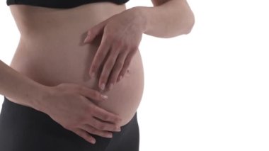 Hamile, beyaz bir kadının karnına yakın çekim. Müstakbel anne karnına bakıyor. Büyüteç fırlatıyor. Beyaz arkaplanda izole.