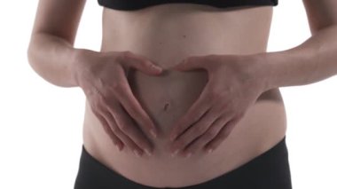 Hamile, beyaz bir kadının karnına yakın çekim. Müstakbel anne karnına bakıyor. Büyüteç fırlatıyor. Beyaz arkaplanda izole.