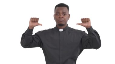 Siyah hoşnutsuz rahibin portresi iki eliyle baş parmaklarını aşağı gösteriyor ve beyaz arka planda izole edilmiş bir şekilde başını sallıyor..