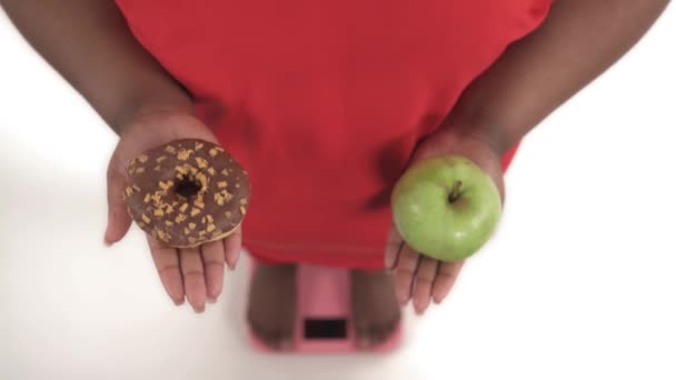 Portret Afrykańskiej Kobiety Nadwagą Wadze Wybierając Wśród Pączków Jabłek Ostatecznie — Wideo stockowe