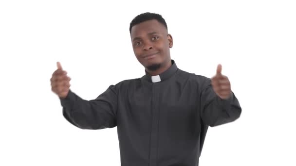 満足したアフリカの司祭の肖像画は カメラで親指を見せます彼の背中をわずかに白い背景に隔離 — ストック動画