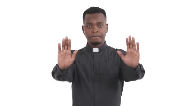 年轻的黑人牧师的画像 在白色背景下举起两只手的手掌 表现出停止的姿势 — 图库视频影像