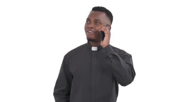 一个快乐的非洲牧师用电话交谈的画像 左手拿着它笑着 对隔离在白色背景下的谈话的好结果表示出满意的叹息 — 图库视频影像
