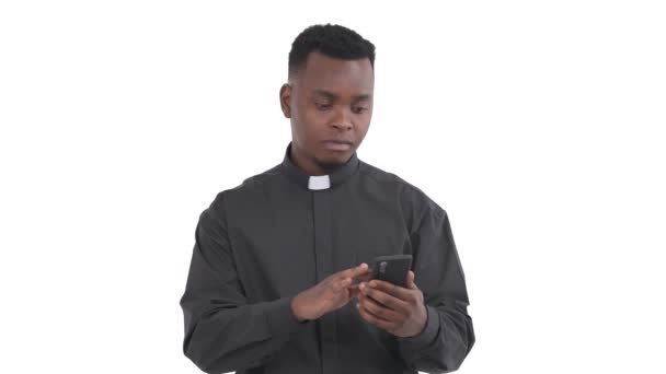 Retrato Sacerdote Negro Sorprendido Sosteniendo Teléfono Mirando Pantalla Del Teléfono — Vídeo de stock