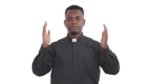 已平复的黑人牧师的画像 举手表决 手心紧握 闭着眼睛 在白色的背景下 慢慢地表现出纳马斯特的姿势 — 图库视频影像