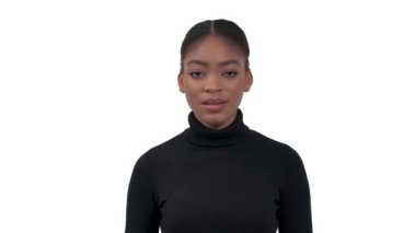 Siyah yakalı polo giyen, kameraya bakıp peçeteye veya mendile hapşıran Afrikalı genç bir kadının portresi. Beyaz arkaplanda izole edilmiş.