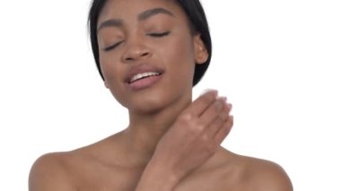 Genç Afrikalı bir kadının pamukla boynuna dokunuşunun portresi. Cilt bakımı ve saflık kavramı. Beyaz bir arkaplanda izole edilmiş