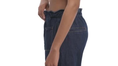 Kocaman pantolonları olan Afrikalı Amerikalı kadın, kilo verme konsepti. İzole edilmiş, beyaz arkaplanda