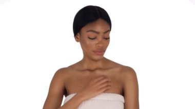 Havluya sarılmış, dekoltesini kaşıyan bir kadının yakın plan görüntüsü. Sağlık sigortası konsepti. Deri tahrişi. Beyaz arkaplanda izole