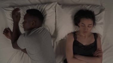 Geceleri yatakta yatan melez çiftlerin en iyi görüntüsü. Beyaz kız kollarını göğsüne bağladı ve uyuyan siyah erkek arkadaşına kızdı.