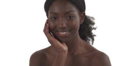 Beyaz arka planda elleri yanağında genç siyahi kadın portresi.