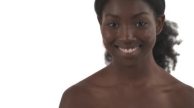 Genç Afrikalı kadının yakın plan portresi gülümseyen ve beyaz arka planda fotokopi çekilen kameraya bakan.