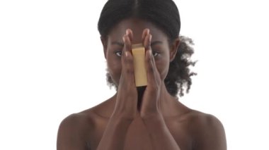 Yüzünün ortasına sünger kaldıran genç siyahi bir kadının portresi ve onu beyaz arka planda sağa sola kaydırıyor.