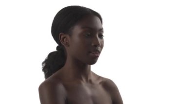 Beyaz arka planda esneyen, ağzını eliyle kapatan genç bir Afrikalı kadının portresi.