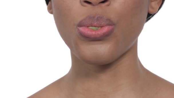 ガムを吹いて美しい唇を持つアフリカの女性のクローズアップ肖像画 隔離された白い背景に — ストック動画