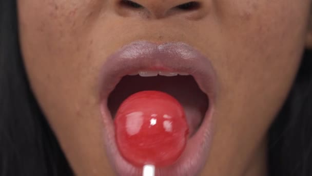 女性のクローズアップ甘いロリポップを食べています 唇に集中しろ 隔離された白い背景に — ストック動画
