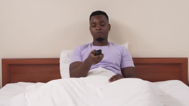 Yataktaki Afrikalı Adamın Portresi Uzaktan Kumandayla Televizyona Çıkıyor Beyaz Bir — Stok video