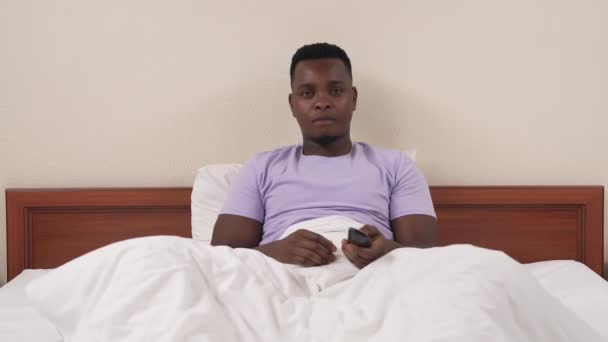 Homme Noir Dans Les Chaînes Commutation Lit Avec Télécommande Trouver — Video