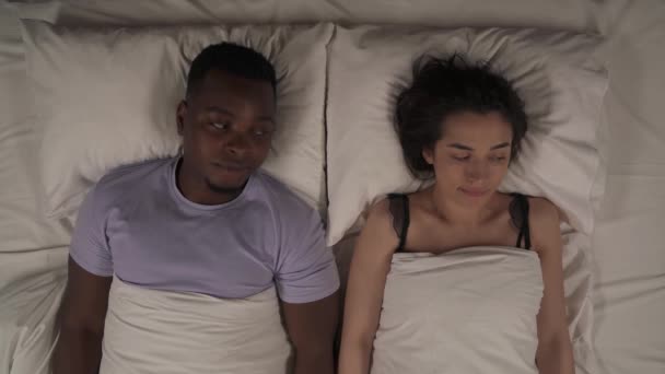 複数のトップビュー 民族のカップルはまだベッドの下に毛布の下に横たわっ側で手を維持する 最初の親密さの前に恥ずかしいと恥ずかしがり屋 — ストック動画