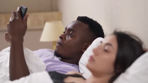 Nahaufnahme Porträt Eines Gemischtrassigen Paares Bett Afrikaner Mit Handy Gekränktes — Stockvideo