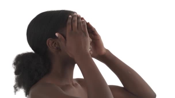 白い背景に若い黒人女性の側面図彼女の顔を撫で ゆっくりとカメラに向かって回します — ストック動画