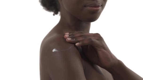 Jeune Femme Africaine Frottant Crème Son Épaule Sur Fond Blanc — Video