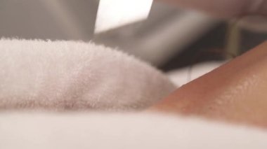 Kozmetik uzmanının müşterinin yüzüne ultrasonik temizleyici sürdüğü yakın çekim bir gösteri videosu. Profesyonel ultrasonik deri soyma. izole edilmiş, bulanık arkaplanda.