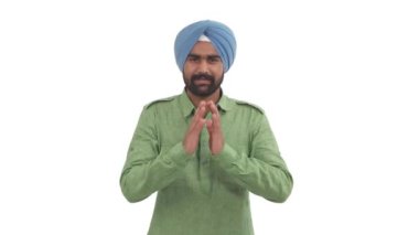Dastar 'daki Hintli sakallı adam hafif yaylı Namaste hareketi yapıyor. Hindu selamı. Beyaz arkaplanda izole
